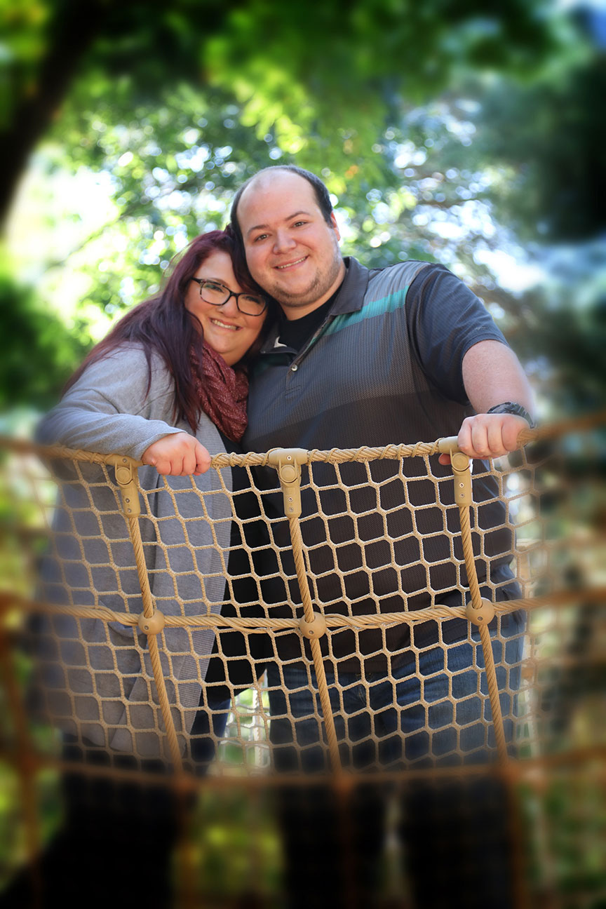 newly engaged couple planning their wedding and posing for engagement photos at Toledo Botanical Garden on the new ropes playground