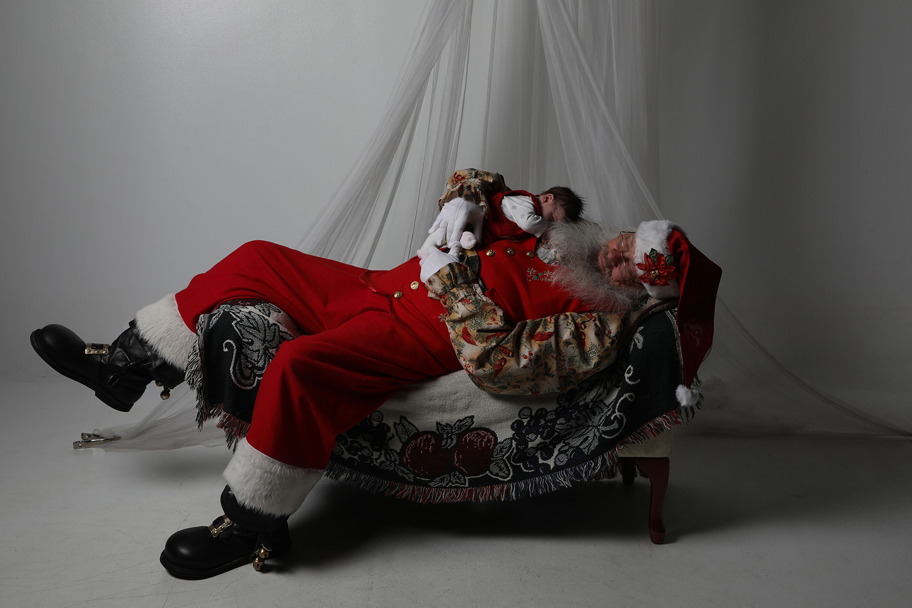 portrait of Santa sleeping with a baby on his chest 
