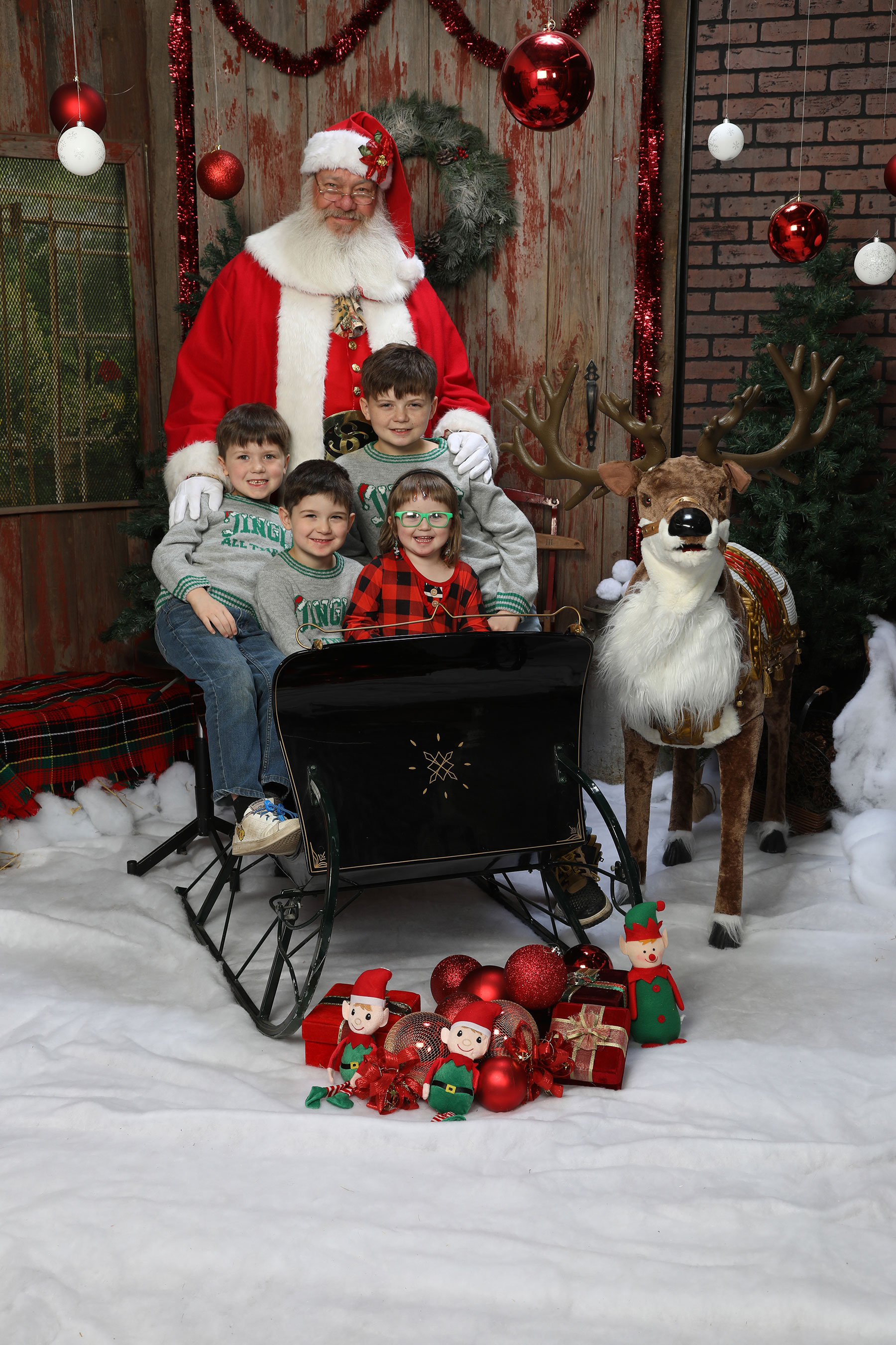 children sitting in a sleigh with Santa and his reindeer