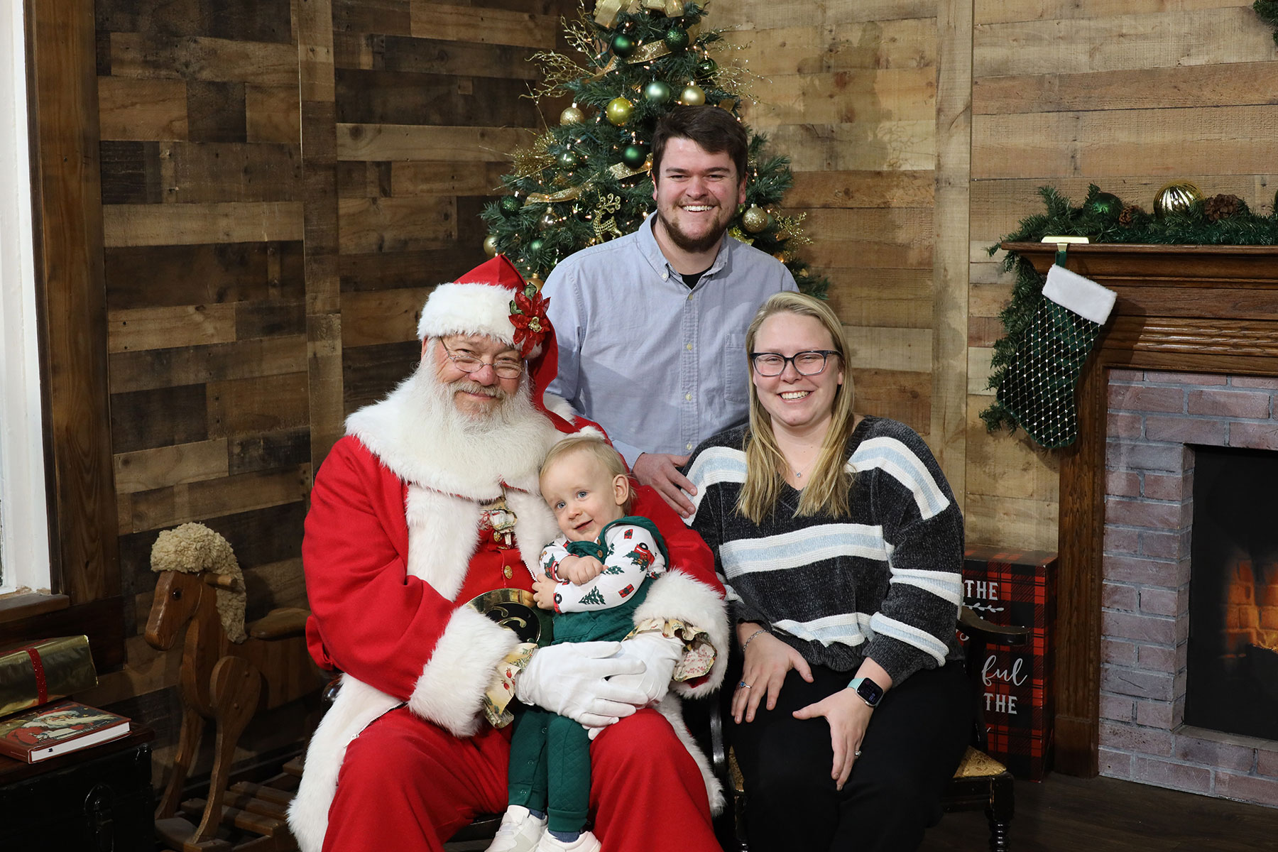 family of three posing for christmas photos with Santa at Kurt Nielsen photography, inc.